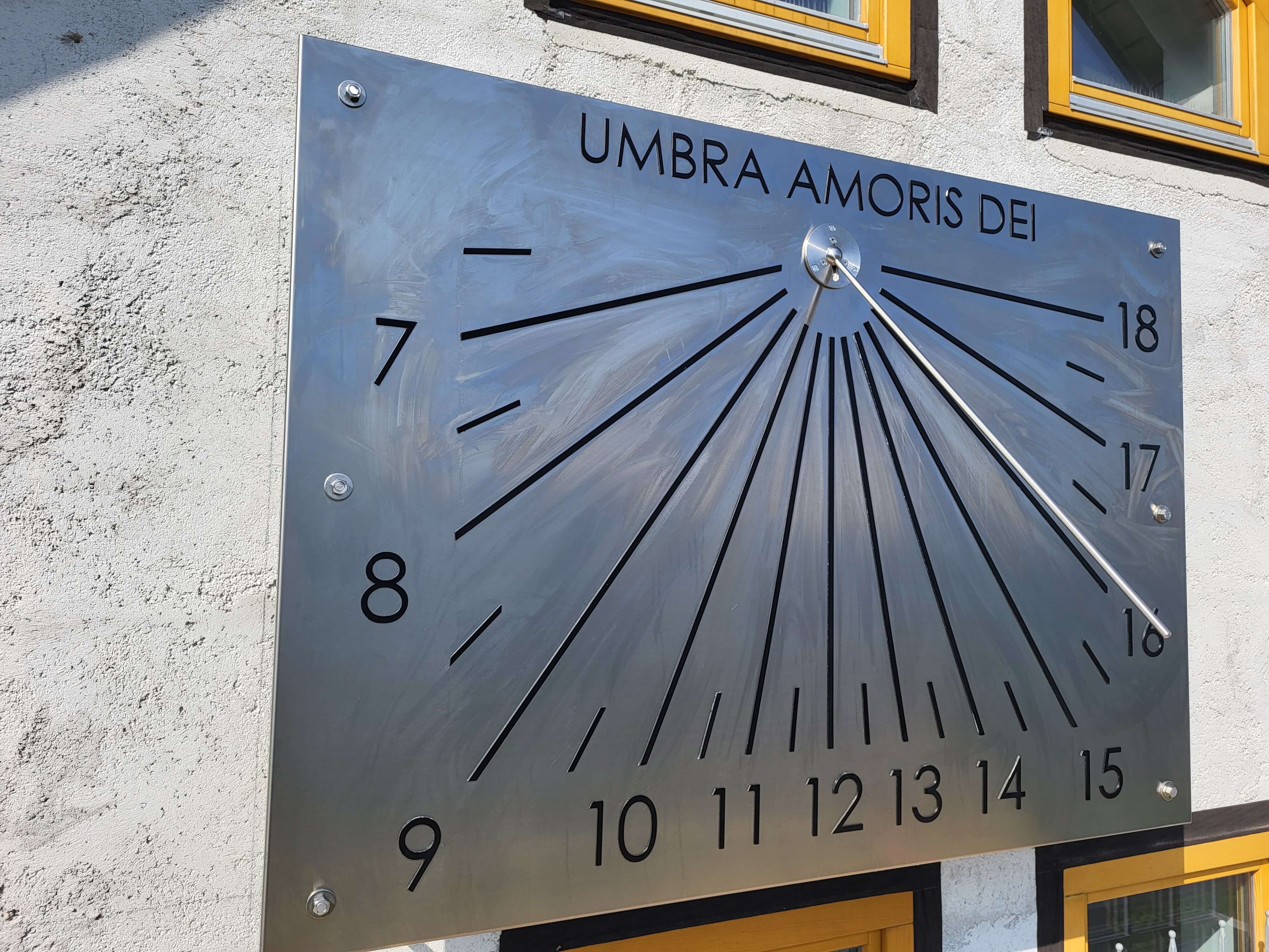 Vertikale Sonnenuhr aus Edelstahl an einer Hauswand